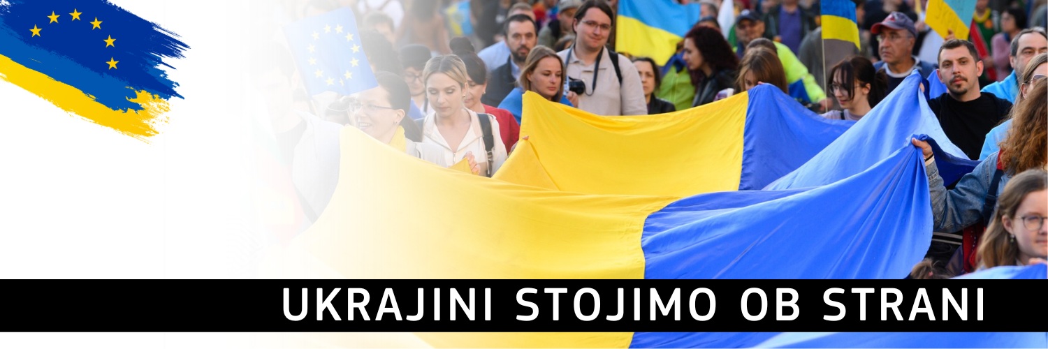 Ukrajini stojimo ob strani (Foto: množica ljudi, ki v podporo Ukrajini demonstrira na prostem z razvito ukrajisko zastavo, v ospredju napis na črni podlagi)