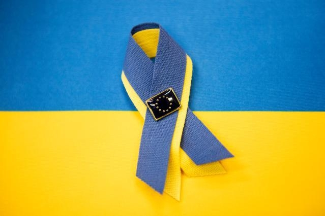 EU-Ukraine (Foto: Ukrajinska zastava na njej pa rumeno zelena pentlja pripeta s priponko, na kateri je zastava EU)