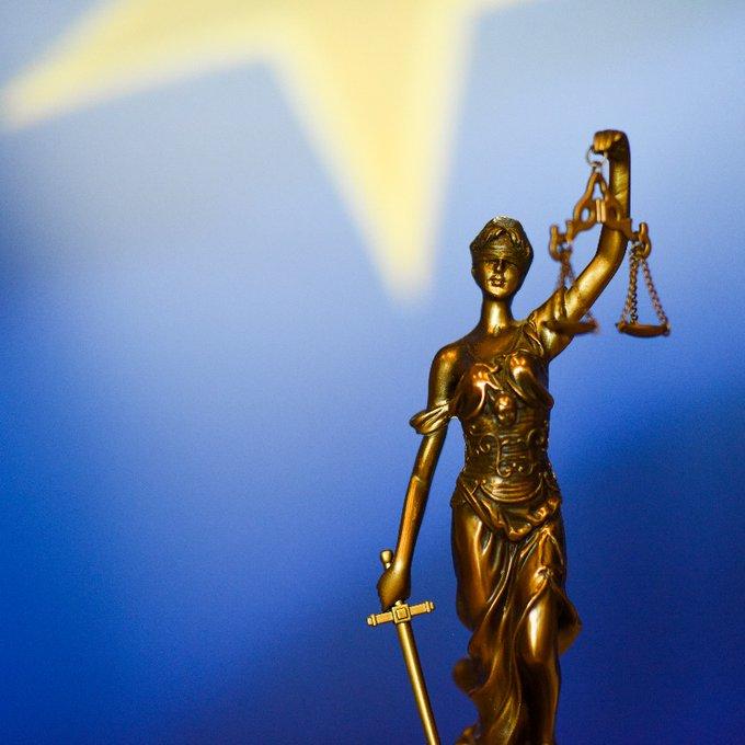 Nov sveženj odločb o kršitvah zakonodaje EU (Foto: bronsti kip Themis, boginje pravičnosti, v ozadju pa delček evropske zastave)