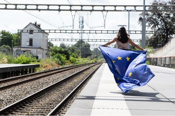 Krepitev upravljanja schengenskega območja  (Foto: dekle hodi ob železniški progi in v rokah drži evropsko zastavo, kiplapola v vetru)