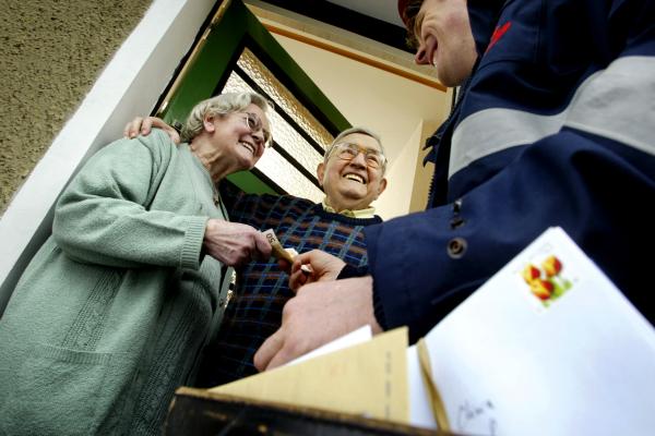 Ustreznost pokojnin za leto 2024 (Foto: starejši par, ki mu poštar predaja denar)